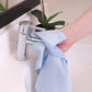 a shiny blue glass cloth cleaning a faucet